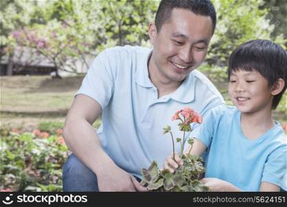 Father and son planting flowers.