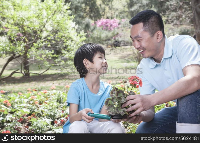 Father and son planting flowers.