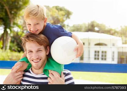 Father And Son Playing Game Of Volleyball In Garden