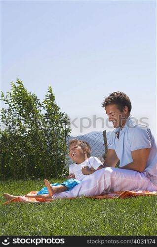 Father and son playing on a picnic rug
