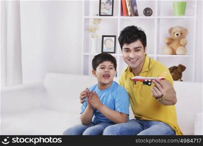 Father and son playing with toy aeroplane
