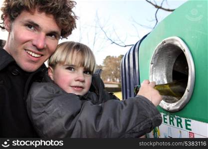 Father and son recycling glass bottles