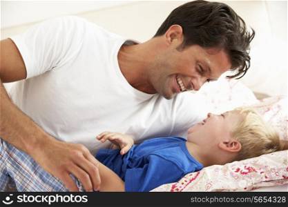 Father And Son Relaxing Together In Bed