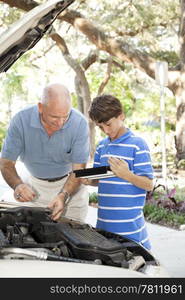 Father and son repairing the car. Vertical view with room for text.