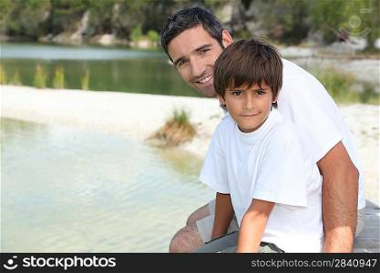 Father and son sat by the lake