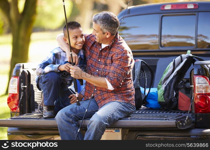 Father And Son Sitting In Pick Up Truck On Camping Holiday