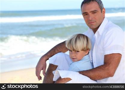 Father and son sitting on a beach