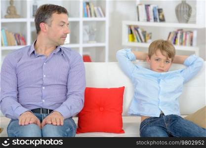 Father and son sitting separately not talking to eachother