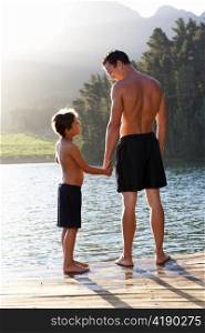 Father and son standing on jetty
