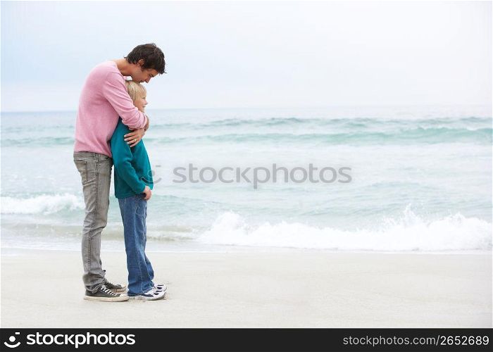 Father And Son Standing On Winter Beach Together