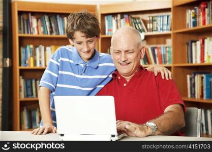 Father and son surfing the internet at the school library.