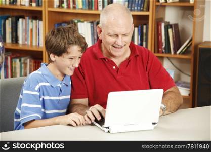 Father and son using the computer in the library.
