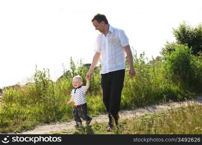 father and son walking on grass