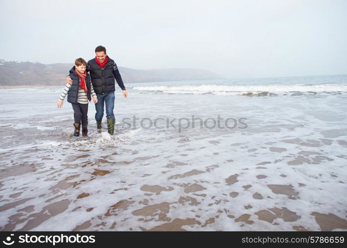 Father And Son Walking On Winter Beach