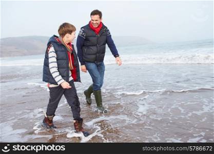 Father And Son Walking On Winter Beach