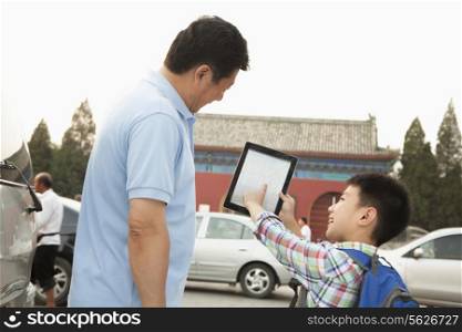Father and son with digital tablet