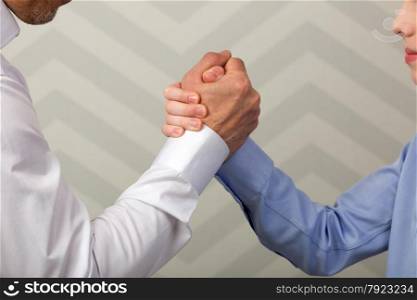 Father and son with hands in strong handshake or during arm wrestling competition. Strong handshake of father and son