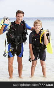 Father And Son With Scuba Diving Equipment On Beach Holiday