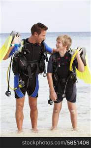Father And Son With Scuba Diving Equipment On Beach Holiday