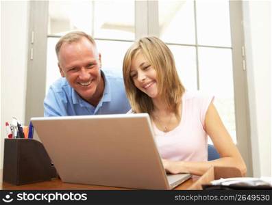 Father And Teenage Daughter Using Laptop At Home