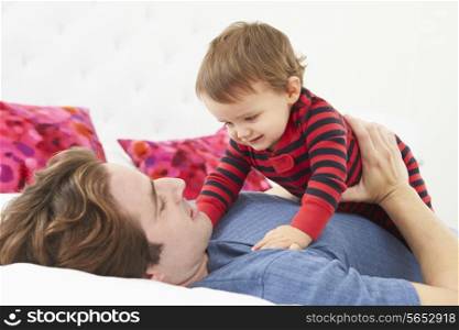 Father And Toddler Lying In Bed Together
