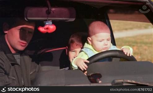 father and two sons having fun in the car