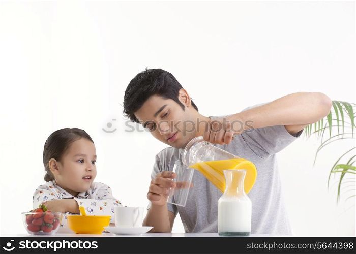 Father and young daughter having breakfast together