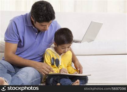 Father assisting his son in drawing at home