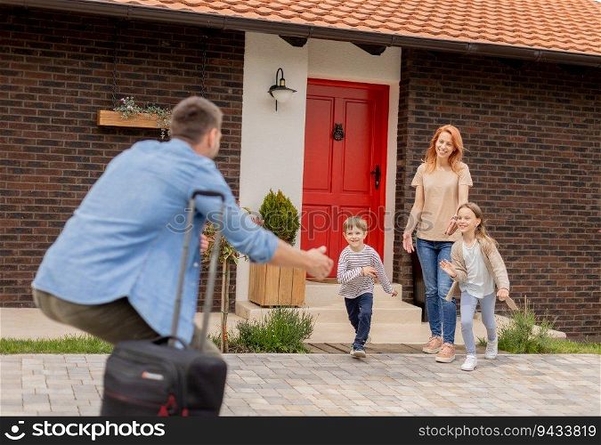 Father came home from the trip and happy son, daughter and wife running to meet him