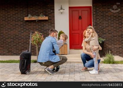 Father came home from the trip and happy son, daughter and wife greeting him