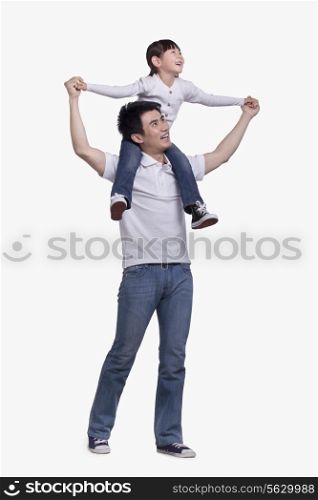 Father carrying daughter on his shoulders, studio shot