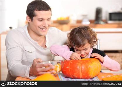 Father carving pumpkins with his daughter