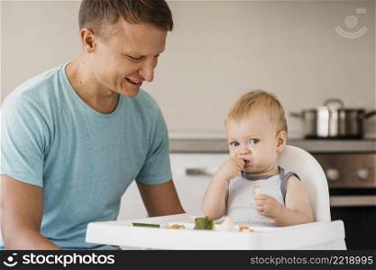father cute baby highchair eating