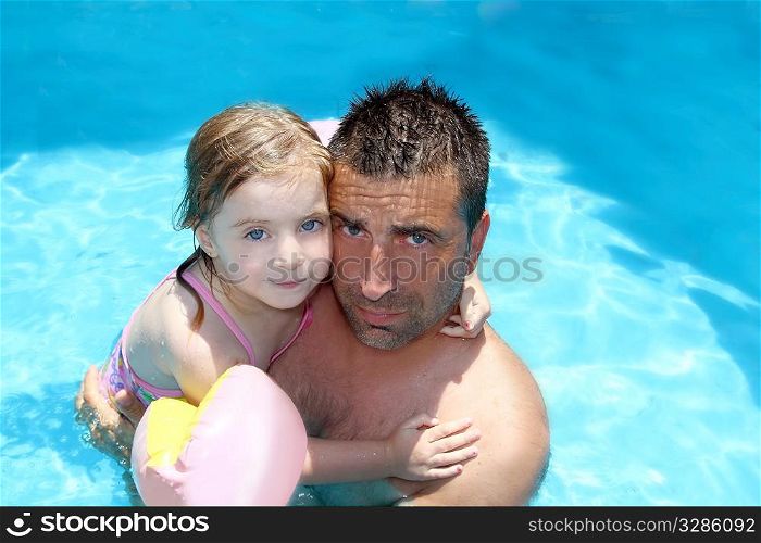 father daughter hug on blue swimming pool vacation portrait