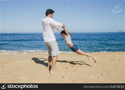 father daughter playing beach
