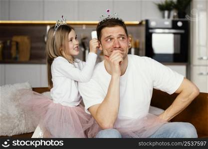 father daughter playing together with tiara