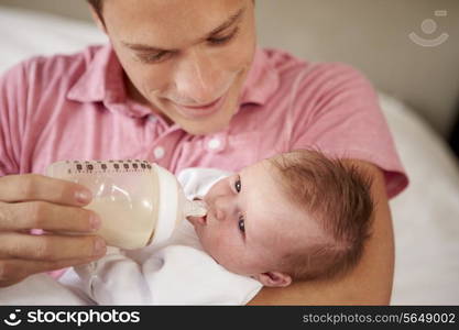 Father Giving Baby Daughter Bottle Of Milk