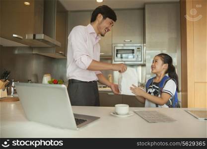 Father giving breakfast to his daughter