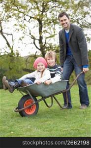 Father Giving Children Ride In Wheelbarrow