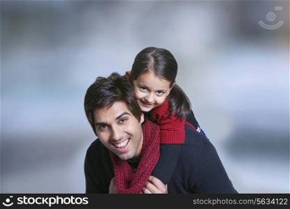 Father giving girl piggy back ride outdoors