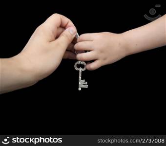 Father giving key to son. Isolated black background