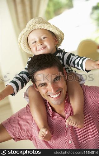 Father Giving Son Ride On Shoulders Indoors
