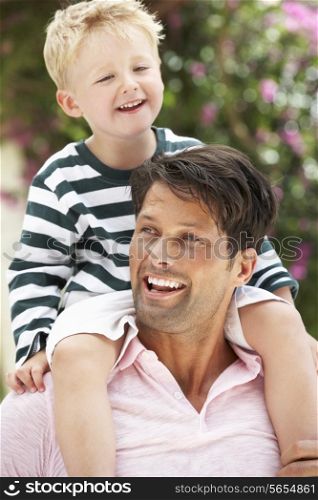 Father Giving Son Ride On Shoulders Outdoors