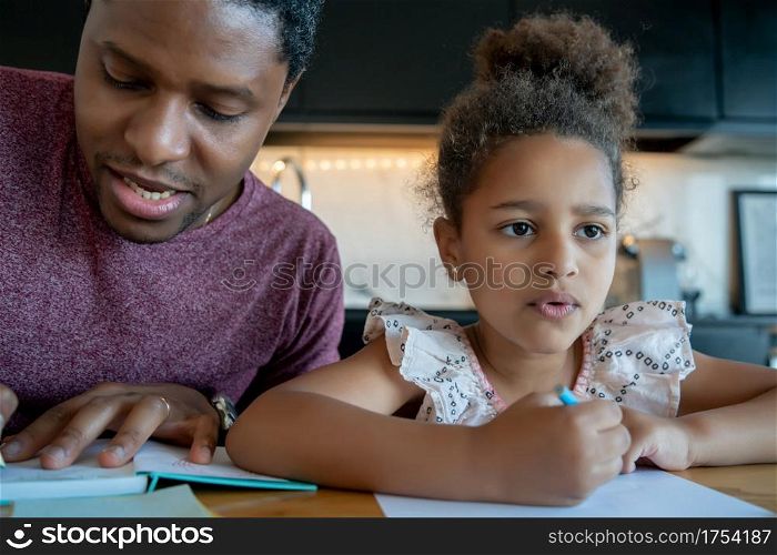 Father helping and supporting his daughter with homeschool while staying at home. New normal lifestyle concept.