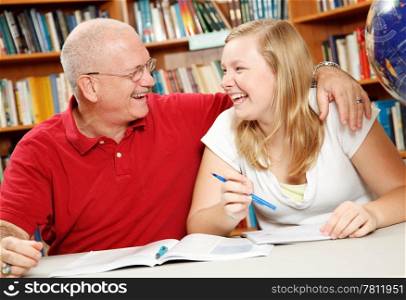 Father helping his daughter do homework, in the library.