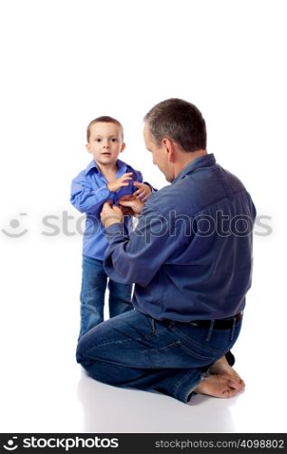 Father helping his son fastening his shirt buttons