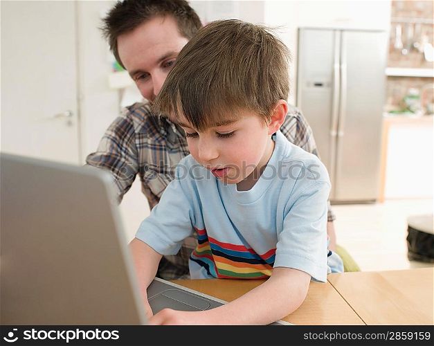 Father Helping Son Use Laptop