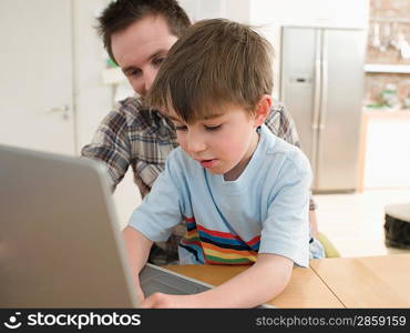 Father Helping Son Use Laptop