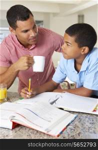 Father Helping Son With Homework In Kitchen