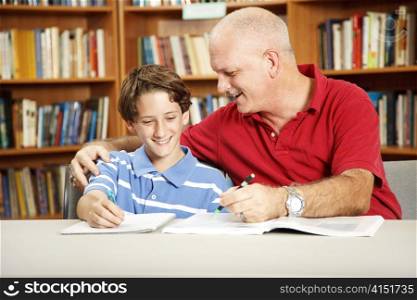 Father helping with his son&rsquo;s homework, in the school library.